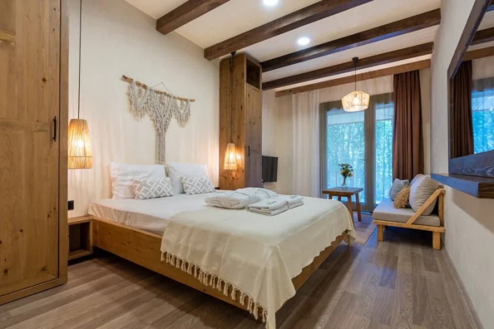 A timber bungalow bedroom at Naturelife with a macramé wall hanging and warm lamplight