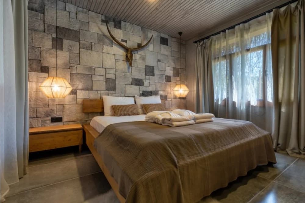 A stone-walled bungalow bedroom at Naturelife