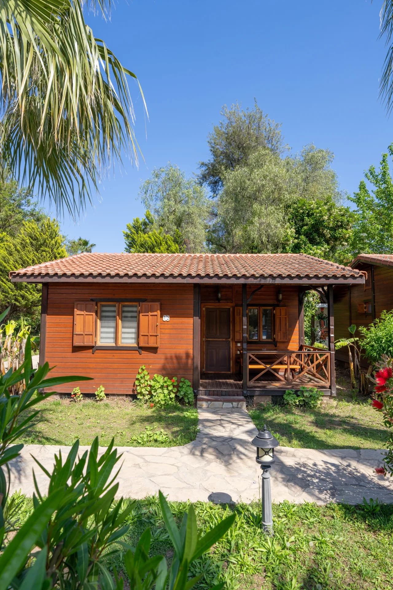 A timber bungalow at Odile Hotel surrounded by garden planting